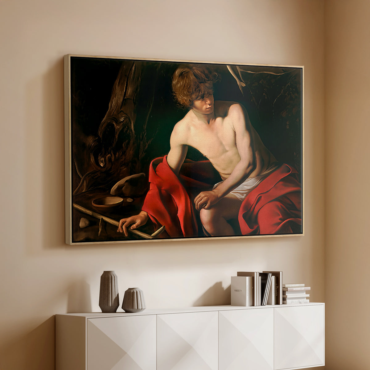 Natural wood floater framed canvas of Saint John the Baptist in the Wilderness, c. 1603-1604 by Caravaggio, featuring a solitary figure of Saint John resting in natural setting with soft light above a console cabinet in a minimalist entryway.
