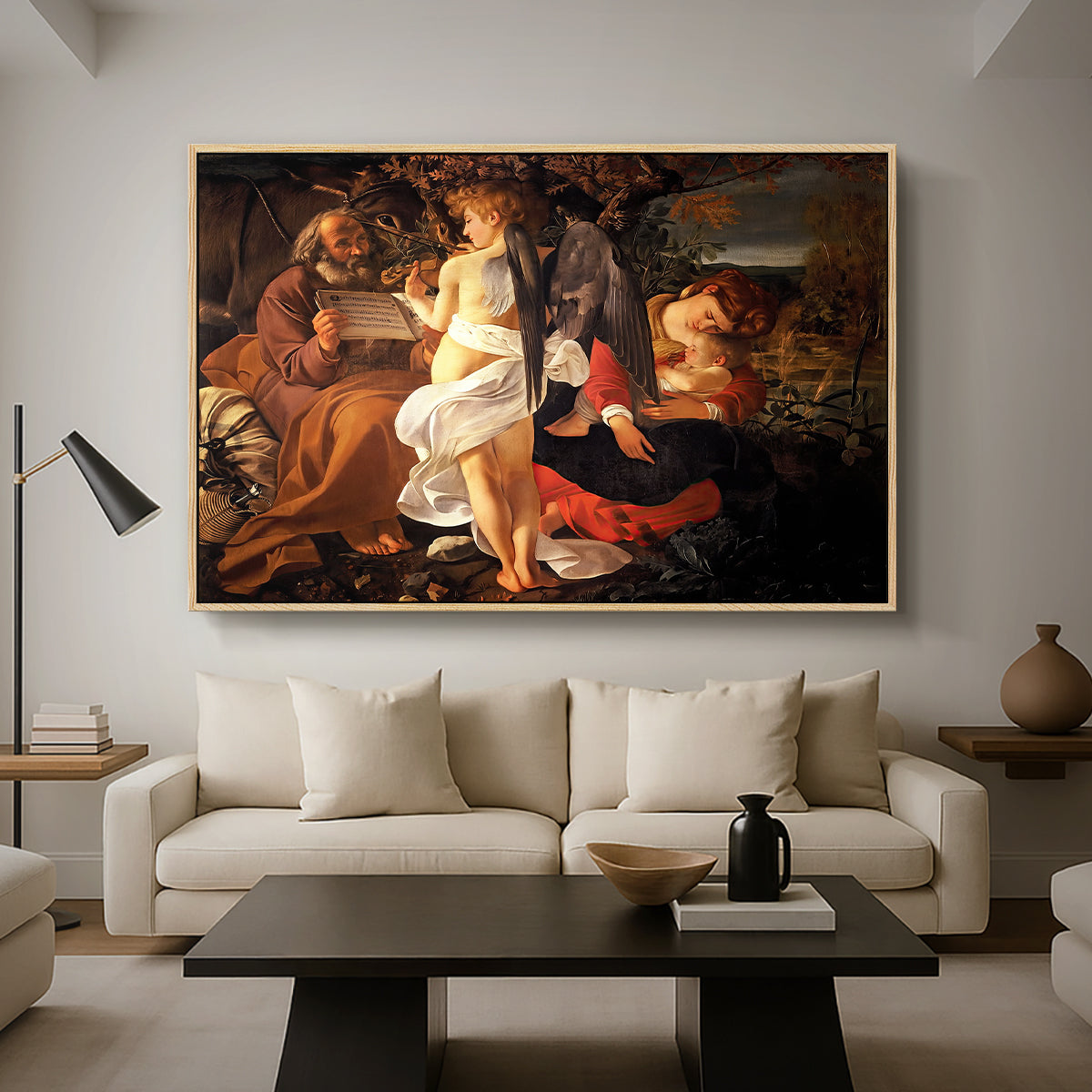 Rest on the Flight into Egypt, c. 1597 by Caravaggio as a natural wood floater framed canvas featuring the Holy Family resting in landscape with angel playing violin, displayed above a sofa in a modern living room.