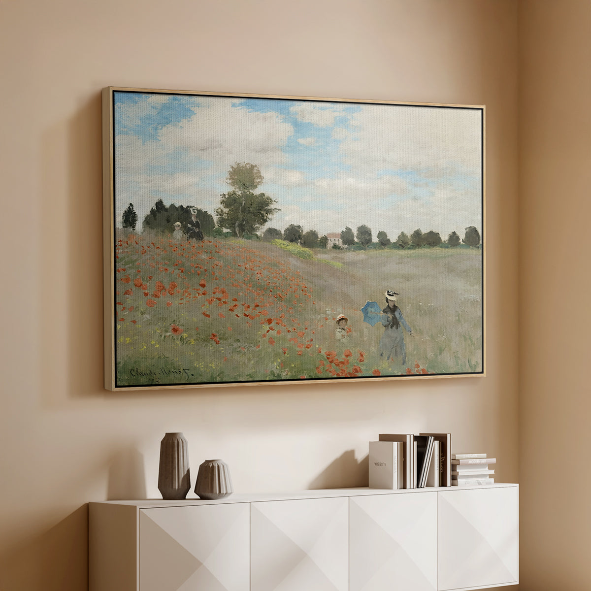 Natural wood floater framed canvas of The Poppy Field near Argenteuil, 1873 by Claude Monet, featuring an impressionist countryside scene with flowers and strolling figures above a console cabinet in a minimalist entryway.