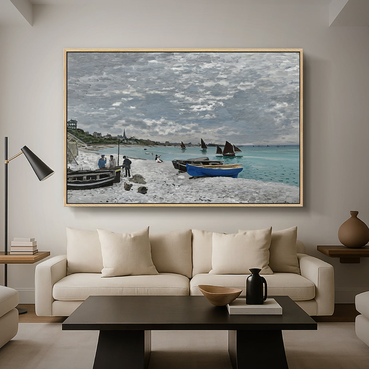 The Beach at Sainte-Adresse, 1867 by Claude Monet as a natural wood floater framed canvas featuring a seaside promenade with figures, flags, and boats along the coast, displayed above a sofa in a modern living room.