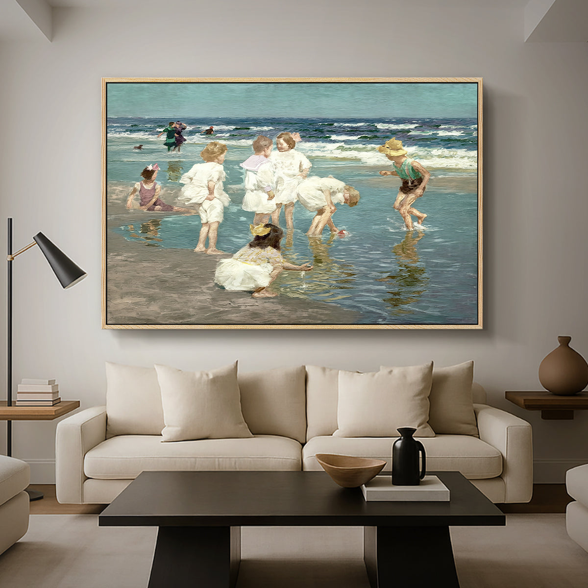A Holiday, c. 1915 by Edward Henry Potthast as a natural wood floater framed canvas featuring people relaxing and wading in shallow ocean water along a sunny beach, displayed above a sofa in a modern living room.