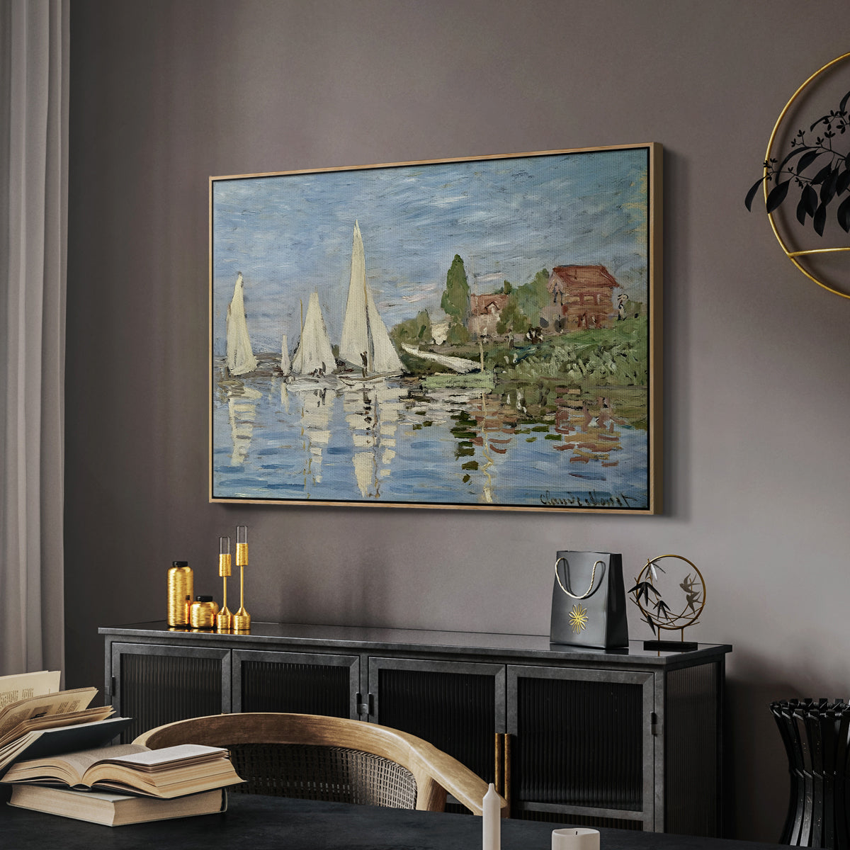 Regatta at Argenteuil, 1872 by Claude Monet in a natural wood floater framed canvas featuring an impressionist depiction of sailing competition on water, displayed above a desk in a dark home office interior.