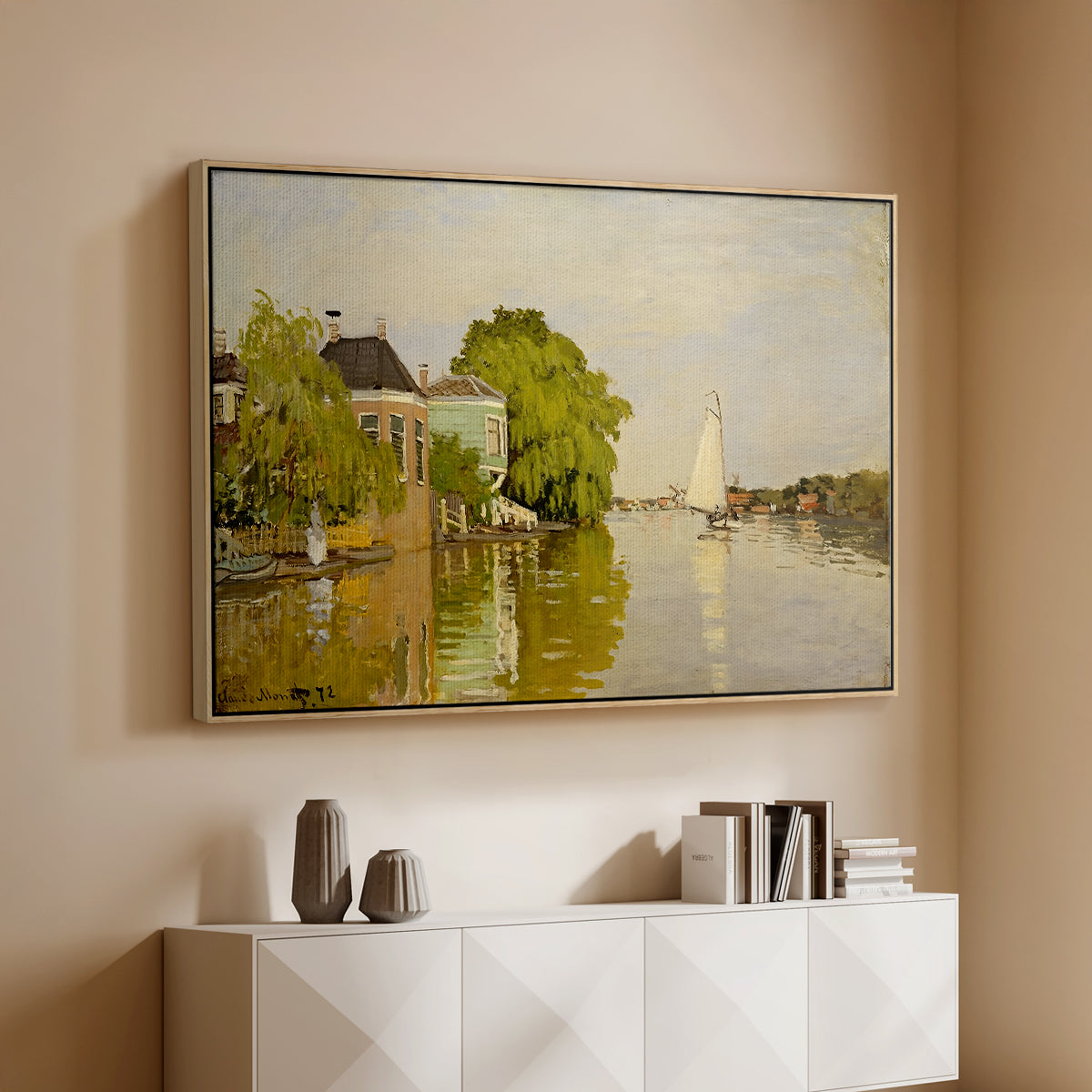 Natural wood floater framed canvas of Houses on the Achterzaan, 1871 by Claude Monet, featuring riverside homes with trees and mirrored reflections in water above a console cabinet in a minimalist entryway.