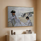 Natural wood floater framed canvas of On the Beach at Trouville, 1870 by Claude Monet, featuring an impressionist seaside scene with women in dresses and hats above a console cabinet in a minimalist entryway.