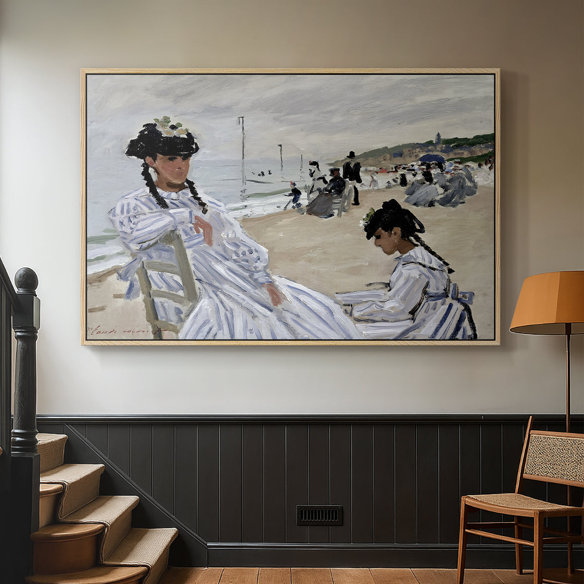 Natural wood floater framed canvas featuring a coastal leisure scene with figures looking out to sea, displayed in a hallway near a staircase.