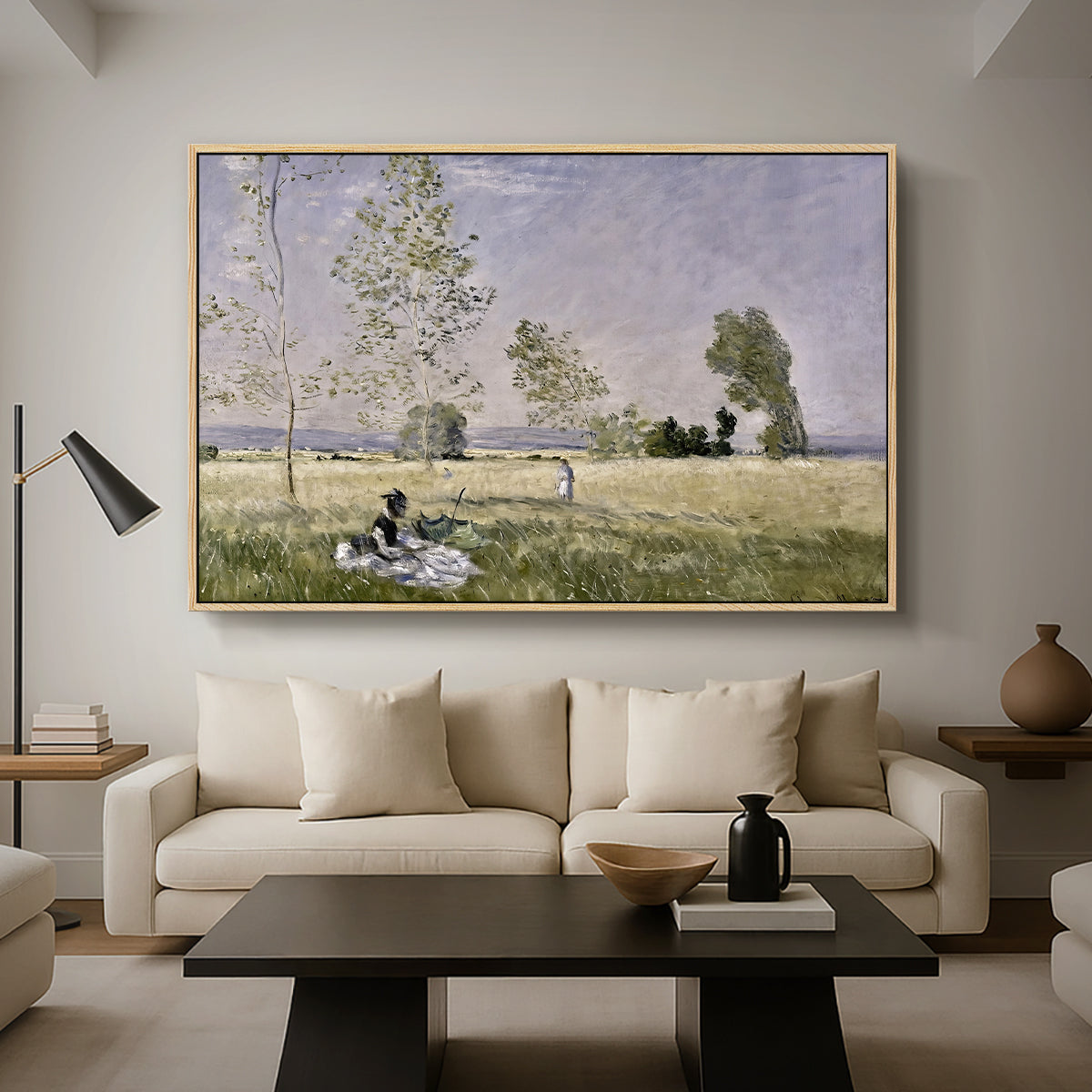 Summer (L'ete), 1874 by Claude Monet as a natural wood floater framed canvas featuring a woman seated in grassy field beneath tree in bright summer landscape, displayed above a sofa in a modern living room.