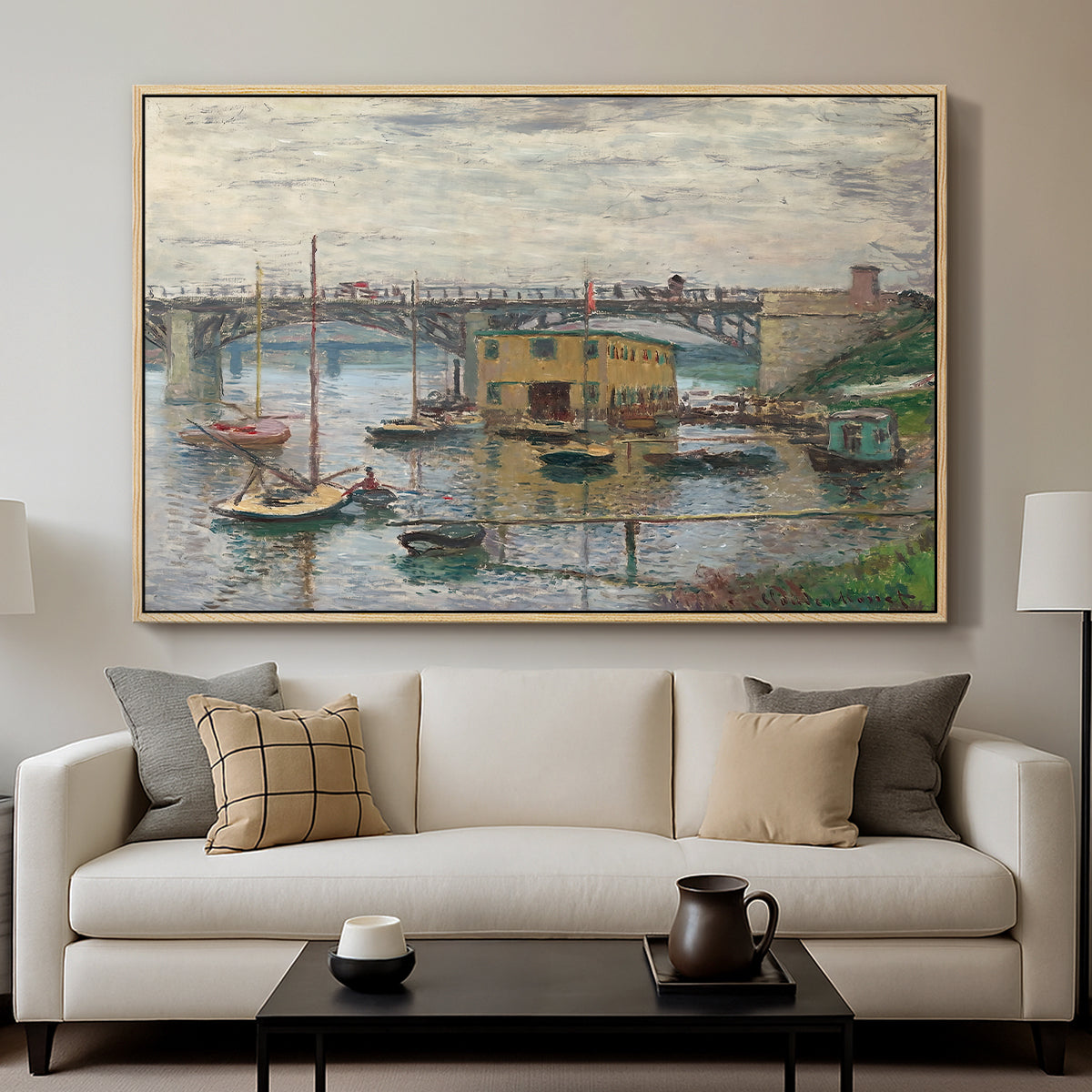 Bridge at Argenteuil on a Gray Day, c. 1876 by Claude Monet displayed in a natural wood floater framed canvas above a sofa in a clean living room.