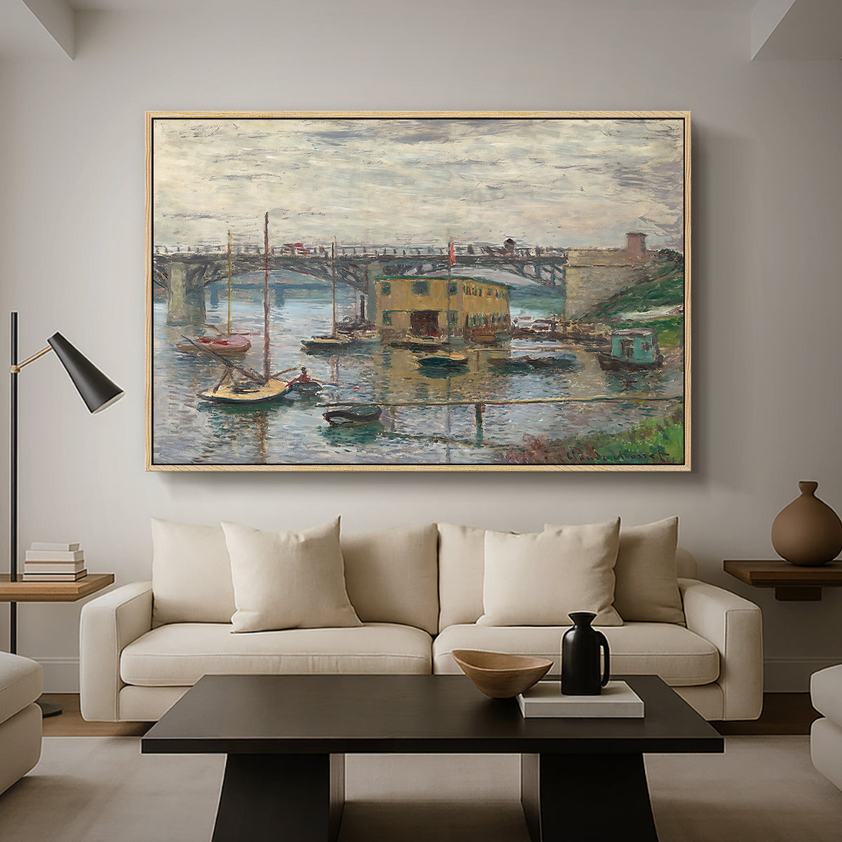 Bridge at Argenteuil on a Gray Day, c. 1876 by Claude Monet as a natural wood floater framed canvas featuring a bridge crossing river under gray sky with muted reflections, displayed above a sofa in a modern living room.