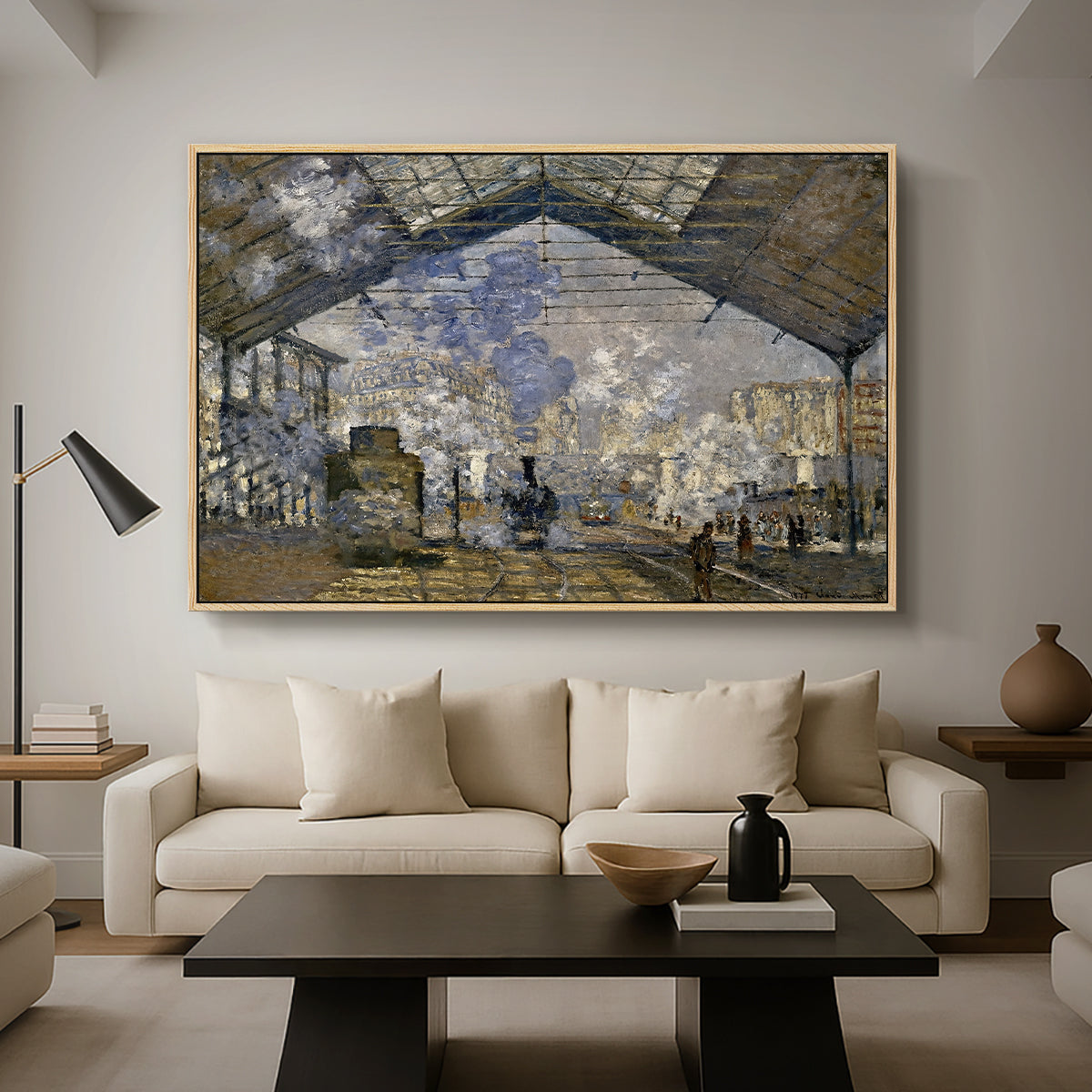 The Gare Saint-Lazare, 1877 by Claude Monet as a natural wood floater framed canvas featuring a train station interior filled with steam and locomotives under iron structure, displayed above a sofa in a modern living room.