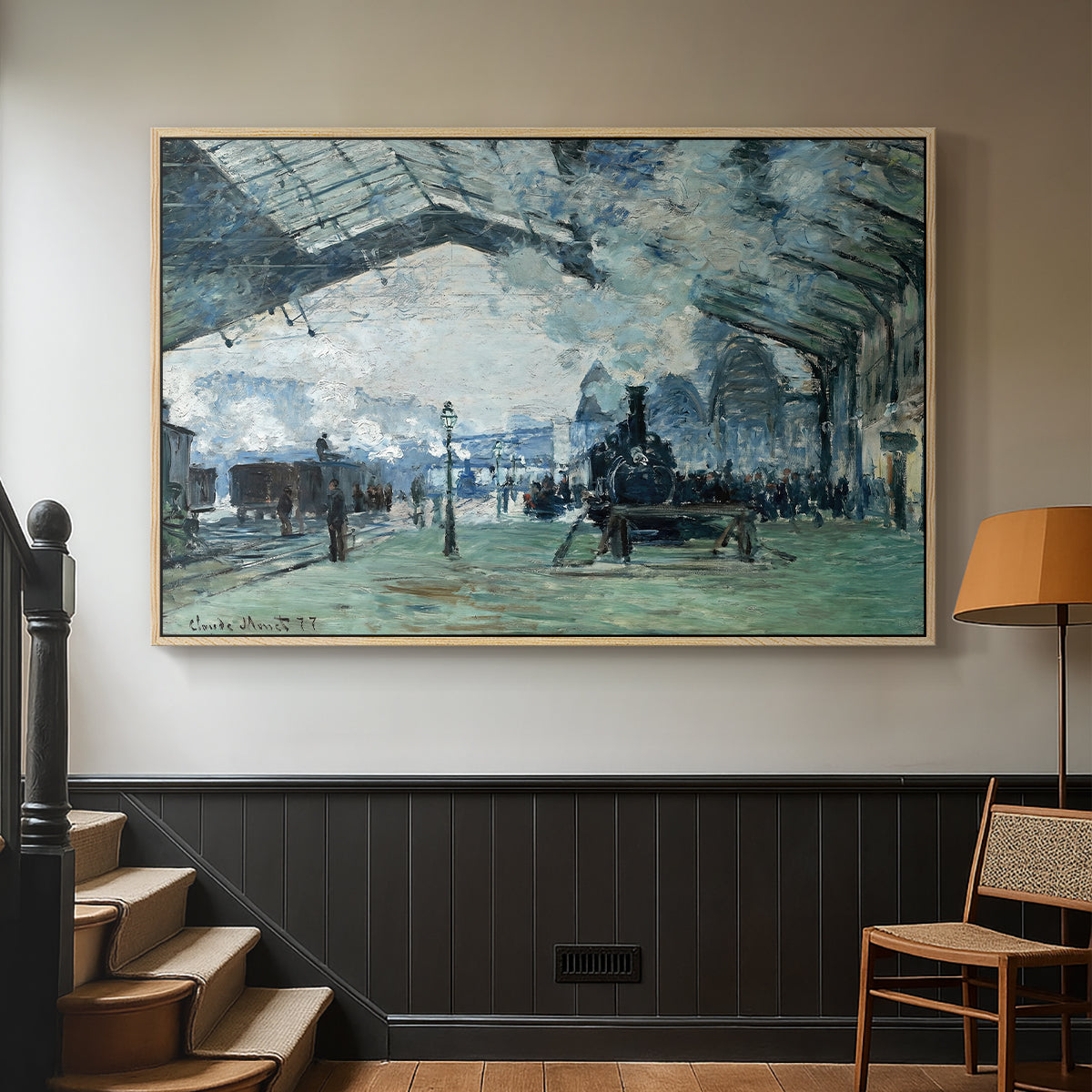 Natural wood floater framed canvas featuring a dramatic depiction of industrial space with trains and light, displayed in a hallway near a staircase.