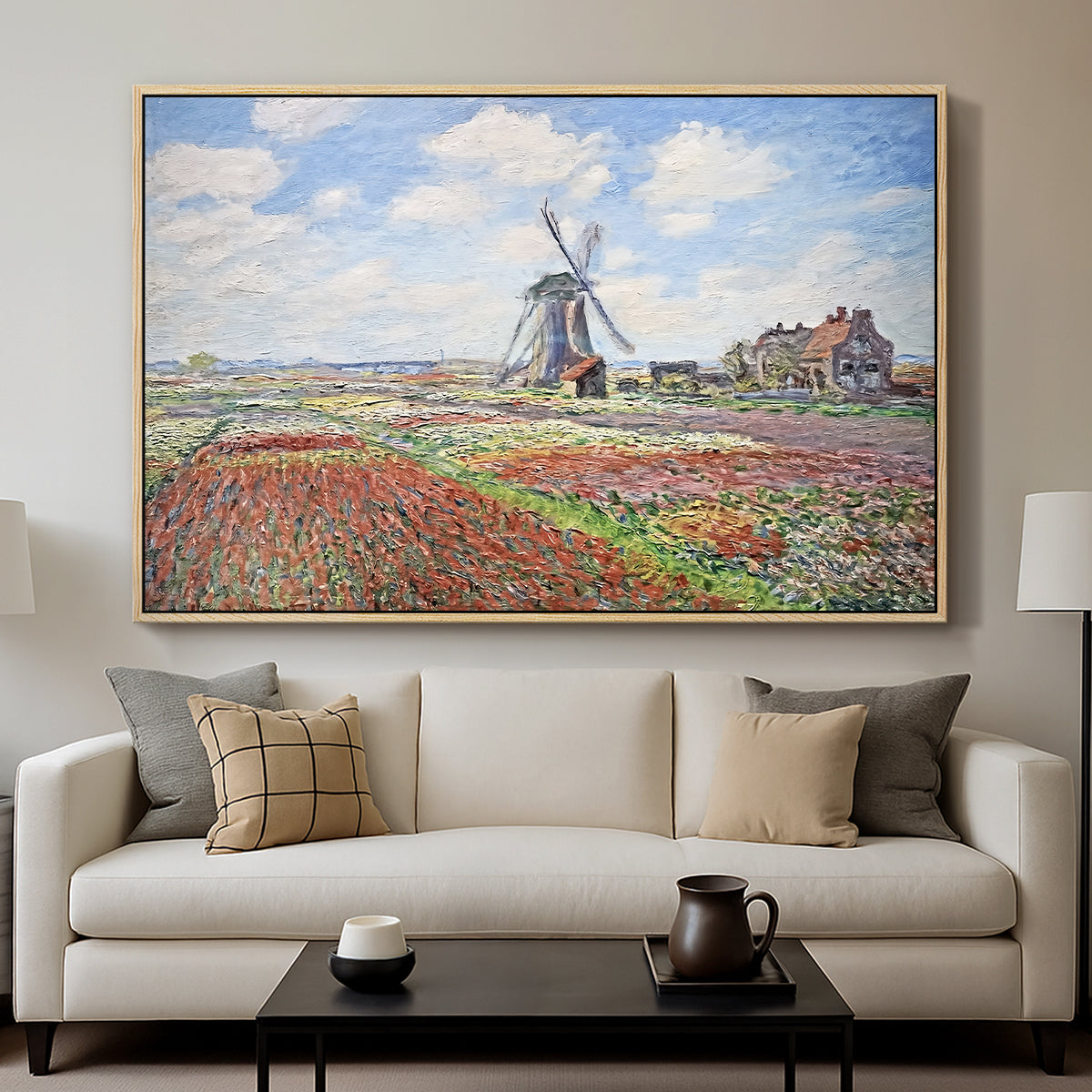 Tulip Fields with the Rijnsburg Windmill, 1886 by Claude Monet displayed in a natural wood floater framed canvas above a sofa in a clean living room.