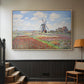 Natural wood floater framed canvas featuring a rural scene with patterned rows of flowers and windmill, displayed in a hallway near a staircase.