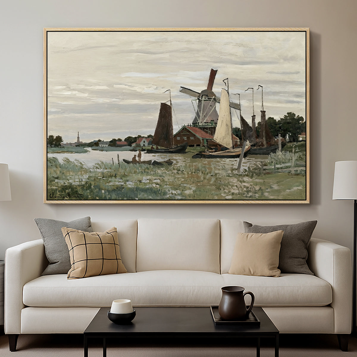 Windmill at Zaandam, 1871 by Claude Monet displayed in a natural wood floater framed canvas above a sofa in a clean living room.