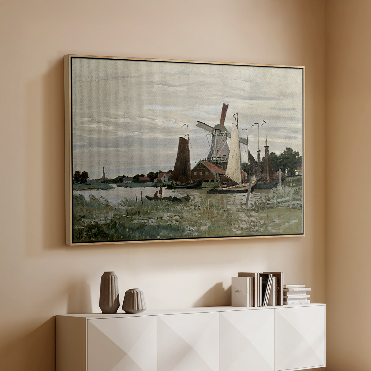 Natural wood floater framed canvas of Windmill at Zaandam, 1871 by Claude Monet, featuring an impressionist depiction of windmill near riverbank above a console cabinet in a minimalist entryway.