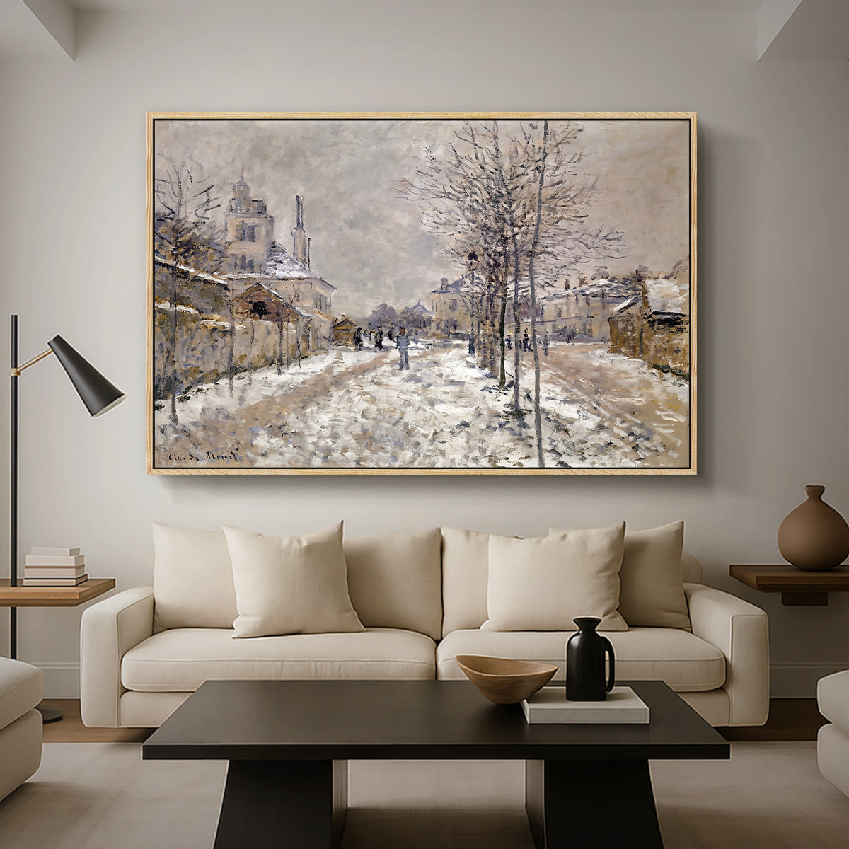 The Boulevard de Pontoise at Argenteuil, Snow Effect, 1875 by Claude Monet as a natural wood floater framed canvas featuring a snow-covered street lined with trees and buildings under winter sky, displayed above a sofa in a modern living room.