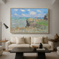 The Cliff Walk at Pourville, 1882 by Claude Monet as a natural wood floater framed canvas featuring figures walking along coastal cliff path overlooking ocean and sky, displayed above a sofa in a modern living room.