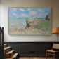 Natural wood floater framed canvas featuring an elevated shoreline path with figures and bright sky, displayed in a hallway near a staircase.
