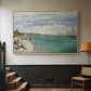 Natural wood floater framed canvas featuring a nautical scene with boats racing near seaside town, displayed in a hallway near a staircase.