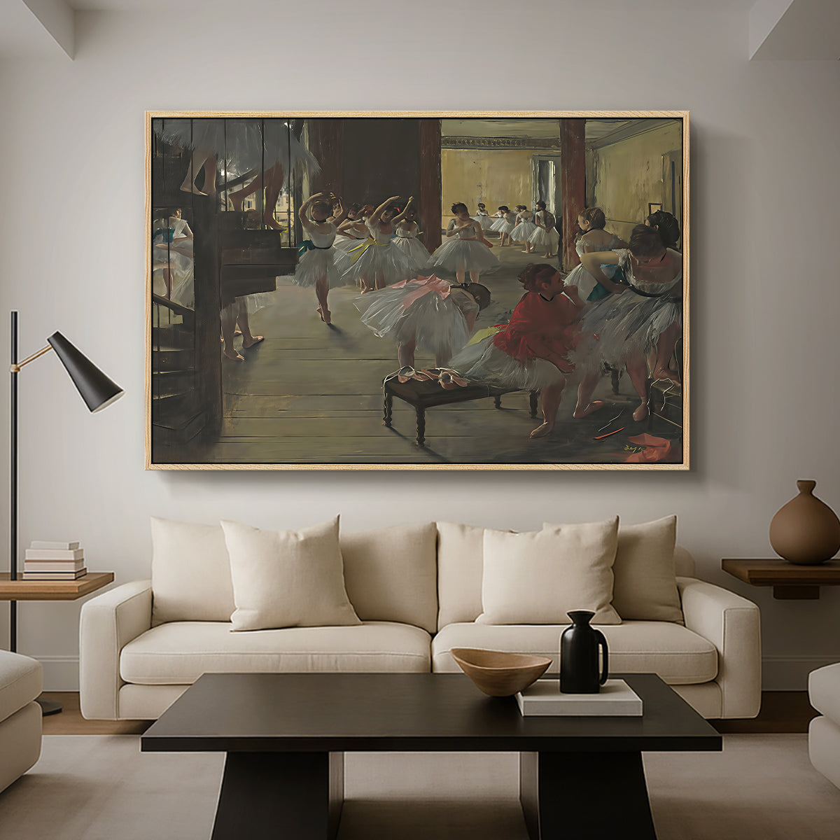 The Dance Class, c. 1873 by Edgar Degas as a natural wood floater framed canvas featuring ballerinas practicing in studio with instructor observing nearby, displayed above a sofa in a modern living room.