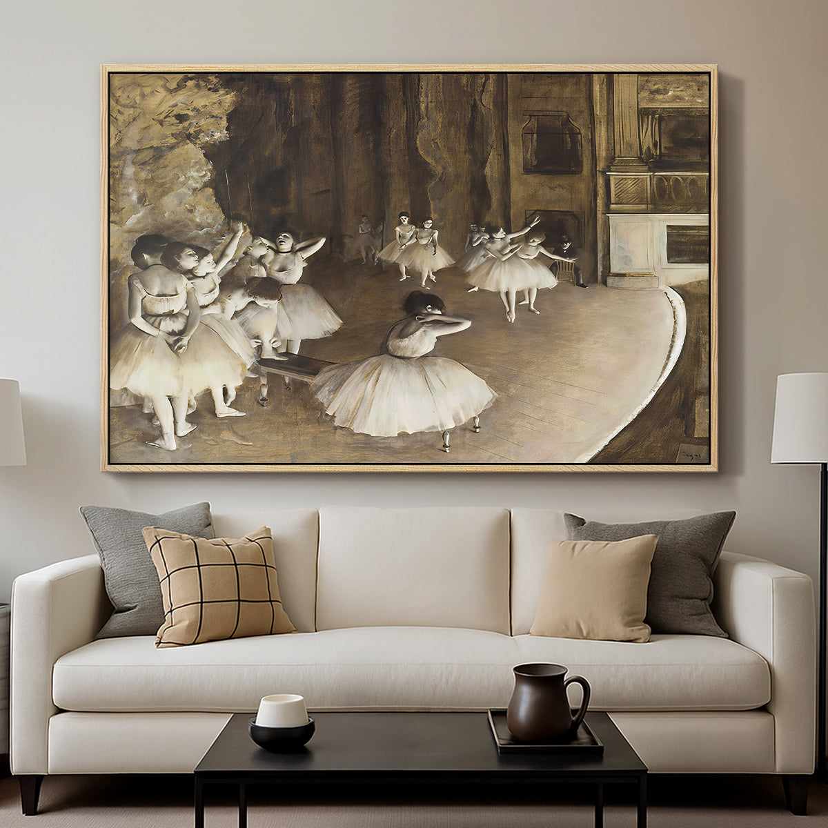 The Rehearsal of the Ballet Onstage, 1874 by Edgar Degas displayed in a natural wood floater framed canvas above a sofa in a clean living room.