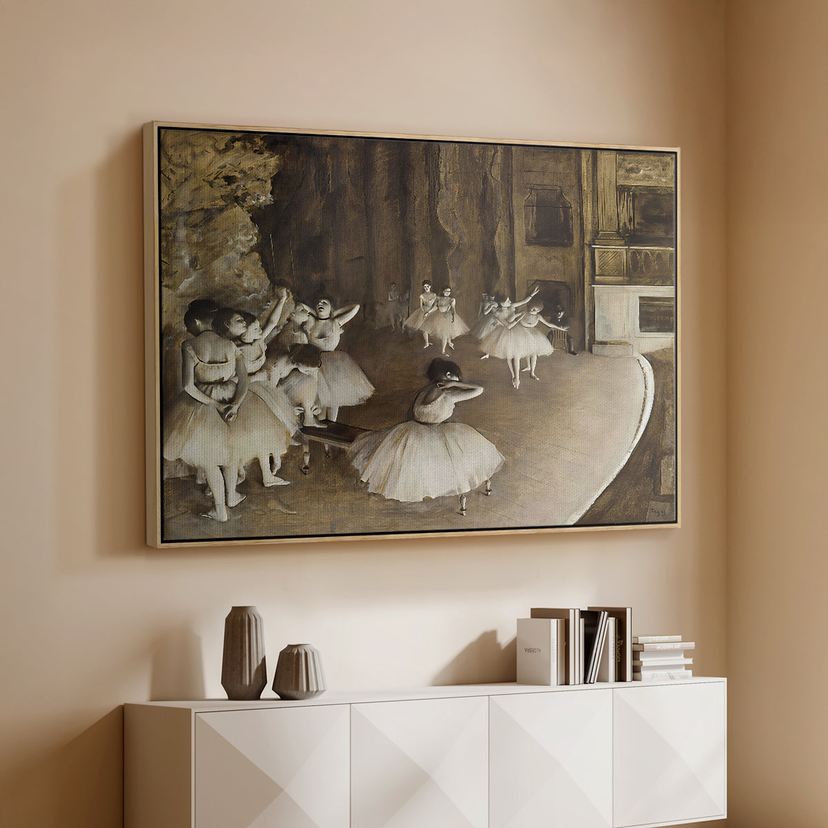 Natural wood floater framed canvas of The Rehearsal of the Ballet Onstage, 1874 by Edgar Degas, featuring a stage rehearsal scene with dancers preparing performance above a console cabinet in a minimalist entryway.