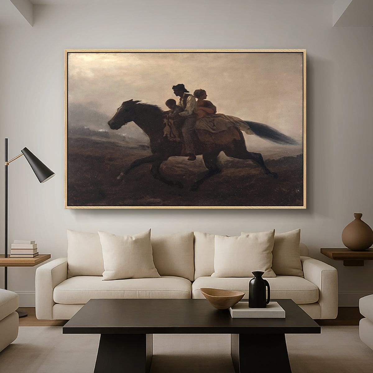 A Ride for Liberty – The Fugitive Slaves, c. 1862 by Eastman Johnson as a natural wood floater framed canvas featuring a family riding horseback through night escaping across landscape, displayed above a sofa in a modern living room.