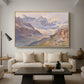 Odenwinklkees with the Johannisberg, 1902 by Edward Theodore Compton as a natural wood floater framed canvas featuring an alpine glacier landscape with rugged peaks and snow-covered terrain, displayed above a sofa in a modern living room.