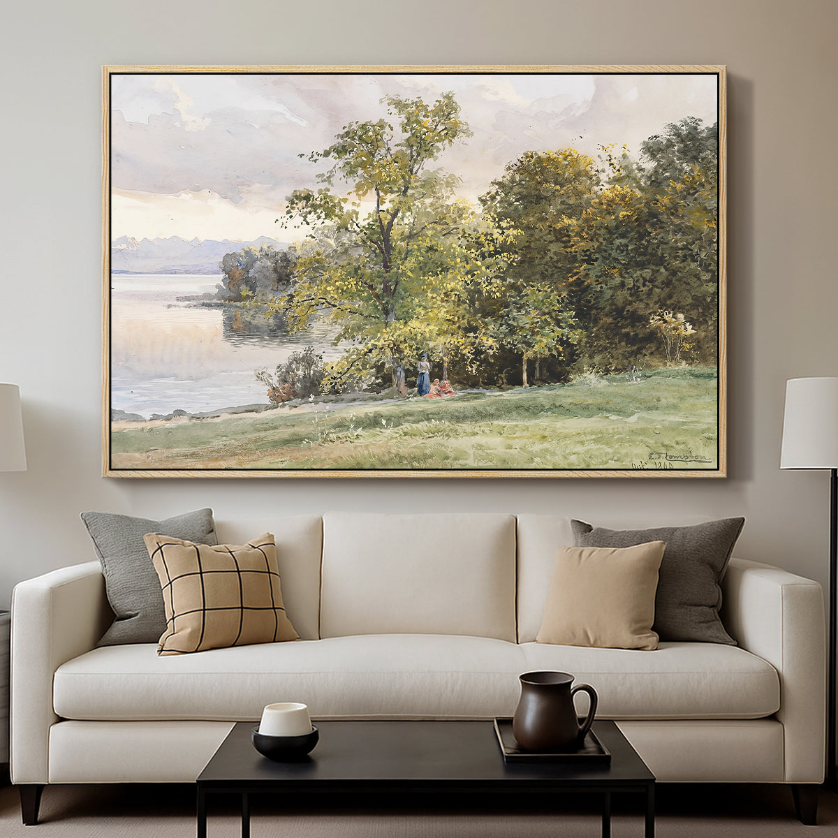 Landscape at Lake Starnberg, 1890 by Edward Theodore Compton displayed in a natural wood floater framed canvas above a sofa in a clean living room.