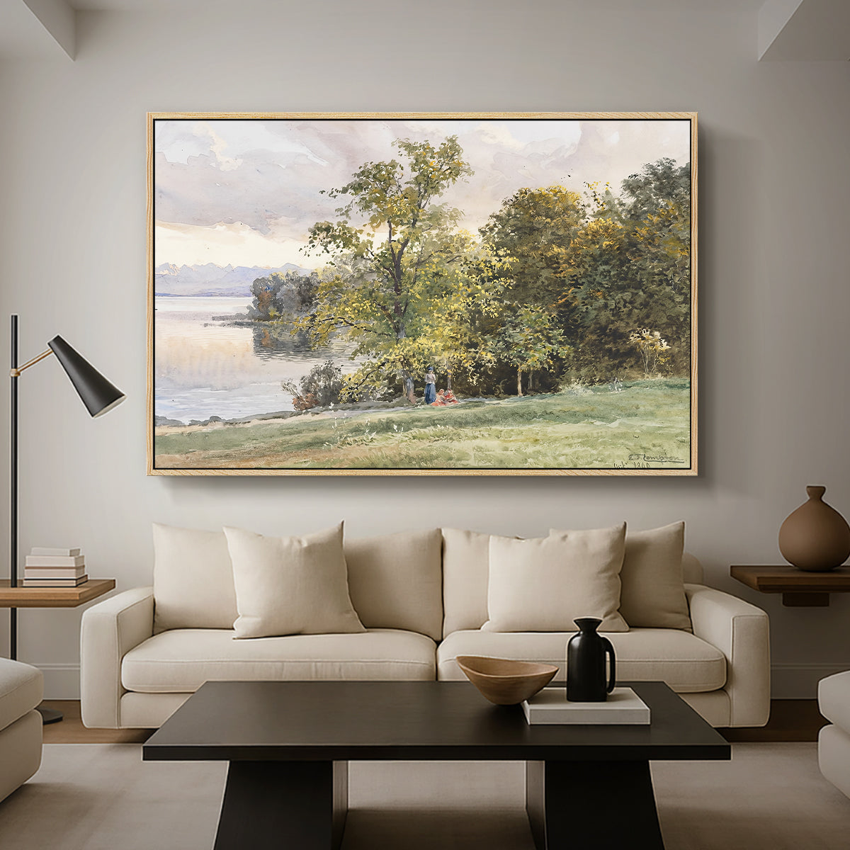 Landscape at Lake Starnberg, 1890 by Edward Theodore Compton as a natural wood floater framed canvas featuring a lakeside landscape with calm water and trees along shoreline, displayed above a sofa in a modern living room.