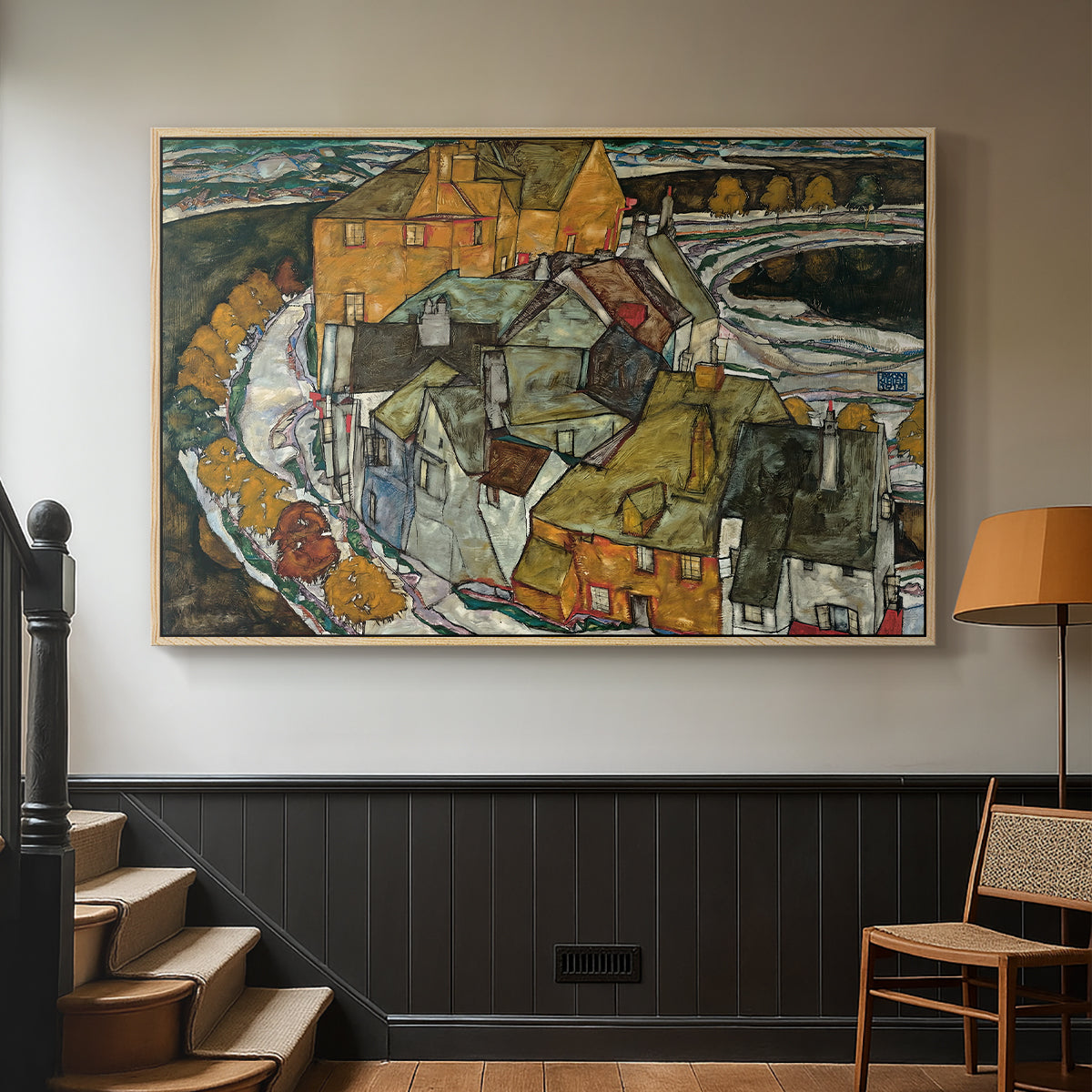 Natural wood floater framed canvas featuring an architectural scene with houses arranged in curved composition, displayed in a hallway near a staircase.