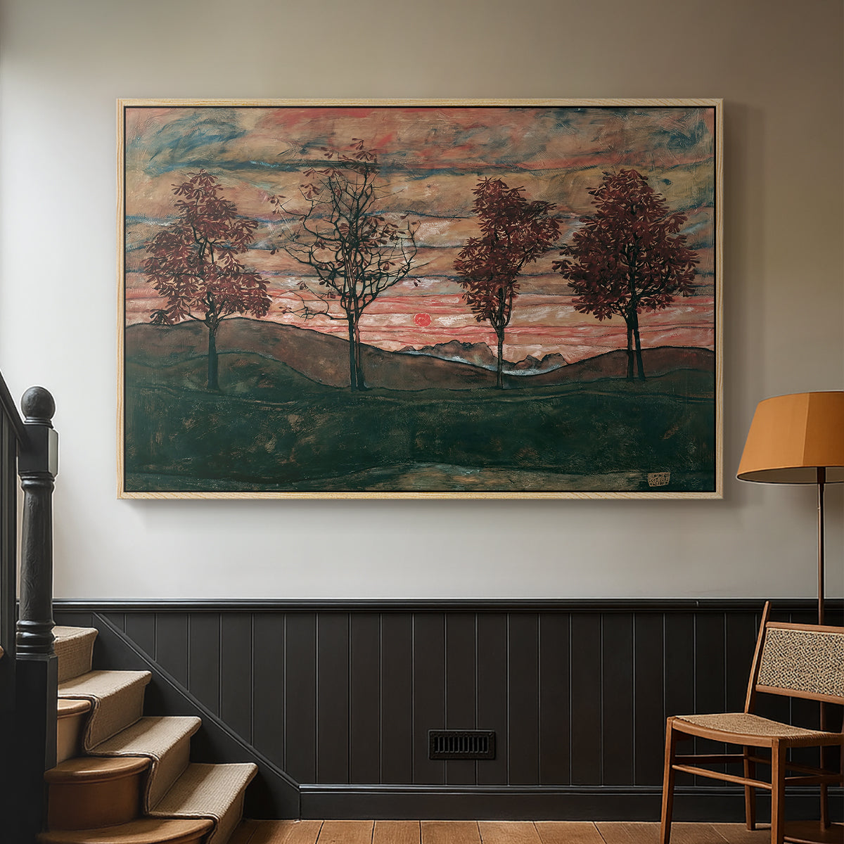 Natural wood floater framed canvas featuring an expressionist landscape featuring isolated trees in field, displayed in a hallway near a staircase.