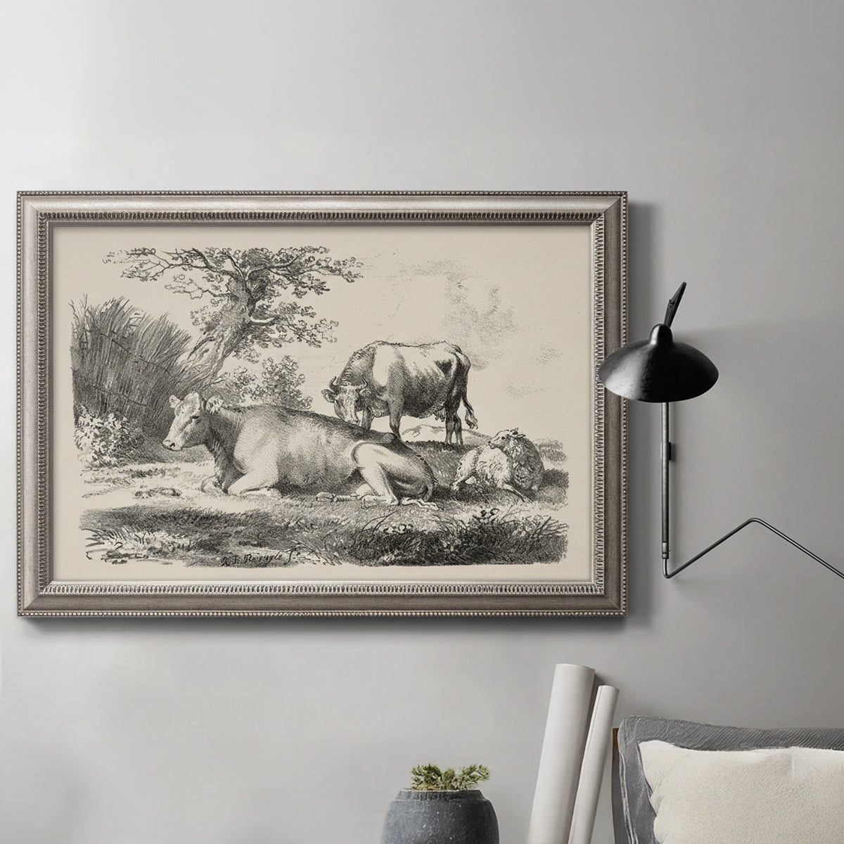 Classical pastoral landscape artwork by Nicolas Berchem in an ornate vintage silver frame displayed in a neutral interior setting.